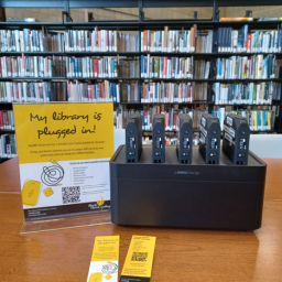 Several charging blocks with sign reading "My Library is Plugged In"