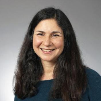 A headshot of Carolyn Sennett against a gray background.