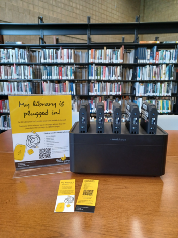 Several charging blocks with sign reading "My Library is Plugged In"