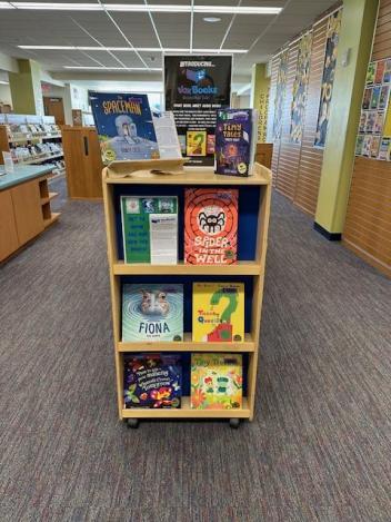 A selection of children's books on a shelf with a sign reading 'Introducing... Vox Books"