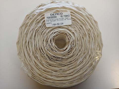 A roll of cream Demco 1/2-inch double-stitched binder tape