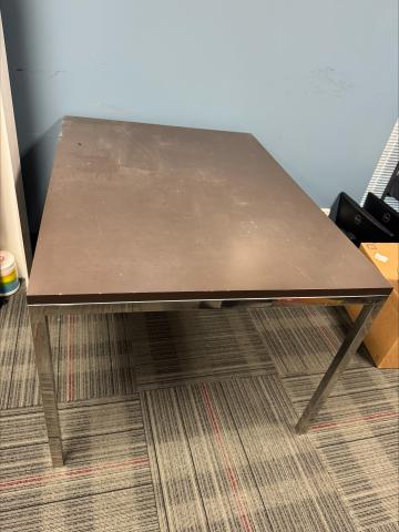 Work table with brown wood laminate top and metal legs