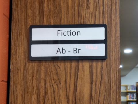 Black acrylic two line range markers for end of book aisles.