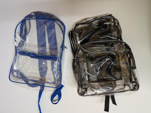 Two clear backpacks, one with black trim and the other with blue trim.