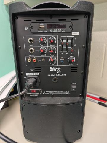 The back side of a speaker, showing various dials and plugs.