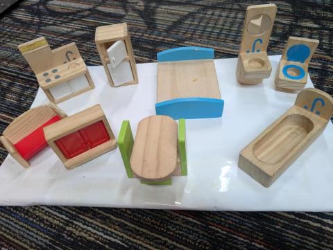 An assortment of small, wooden dollhouse furniture.