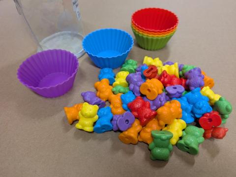 A pile of plastic bears - orange, yellow, green, blue, red, purple - and silicone cupcake liners.