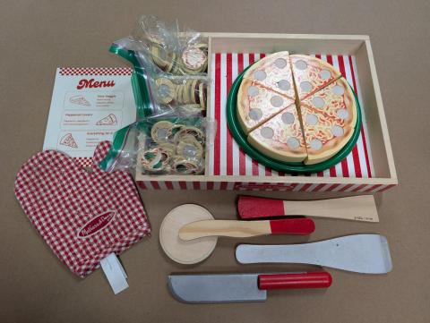 A wooden pizza set, including pizza slices, toppings, and kitchen tools.