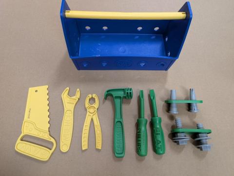 A toy tool box with 6 toy tools and screws/"nails"
