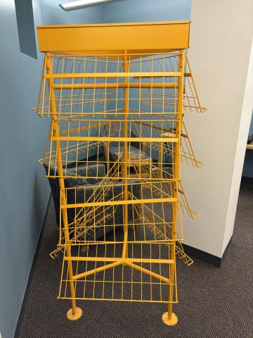 Orange, metal wire rack intended for displaying multimedia resources.