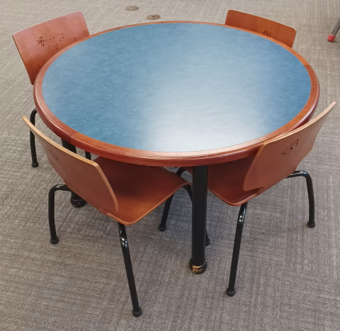 Brown wood table with blue top and matching 4-legged brown wood chairs