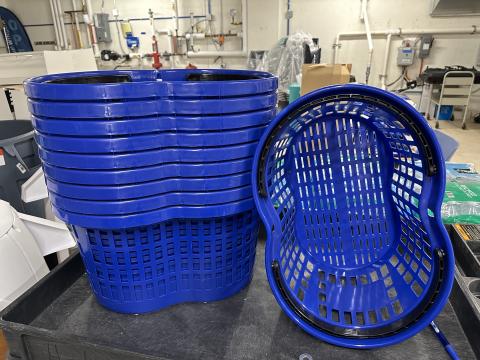 Stack of blue peanut-shaped 2-handle shopping baskets