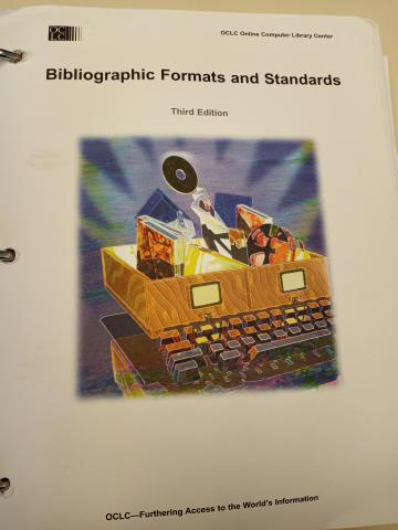 The first page of OCLC's Bibliographic Formats and Standards, showing a keyboard, cataloging drawers, and various materials