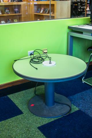 Green round top black rim pedestal base table with integrated power