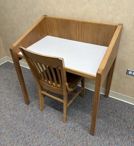 Single person study carrel with one wood chair.