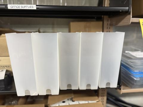 White magazine bins on a shelf