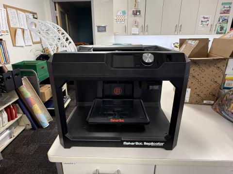 black 3D printer sitting on white countertop