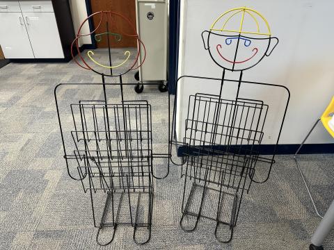 two wire racks with four layered shelves each to display books or items face out. Racks are in the shape of a child.