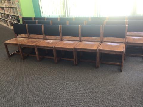 photograph of wooden library chairs with navy blue backrests