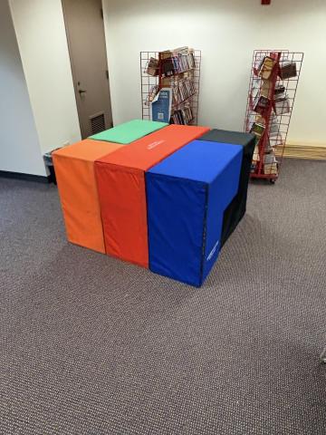 A multi-colored assortment of giant foam puzzle blocks placed together to form a cube.