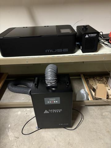 Image of laser and cool box on a shelf with the fume box on the floor in front.