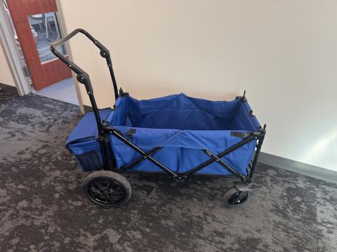 Blue folding wagon with handle and storage bin