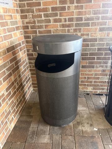 A round, silver trash can 