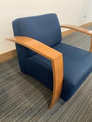 one blue upholstered chair with wooden arms