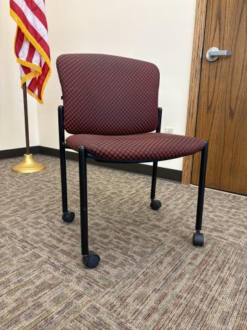 Burgundy cloth chair with casters and no arms
