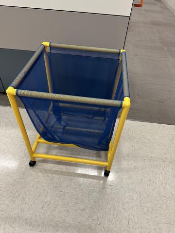 Yellow-framed bin with blue mesh sides on wheels