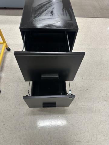 Black metal filing cabinet with two open drawers