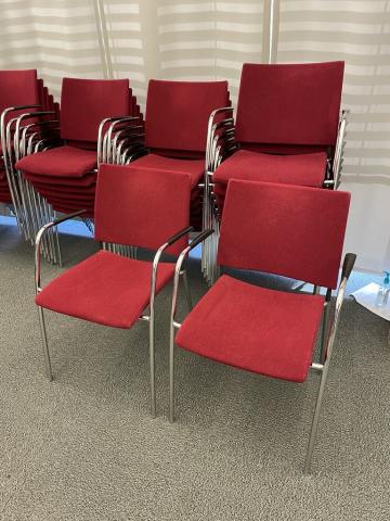 stackable chairs with silver metal arms and legs, red fabric cushion, black armrests