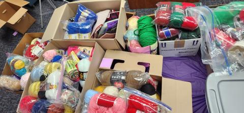 Photo from above of cardboard boxes filled with yarn balls and skeins. 