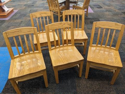 Five child-sized wood chairs in a medium honey color. 
