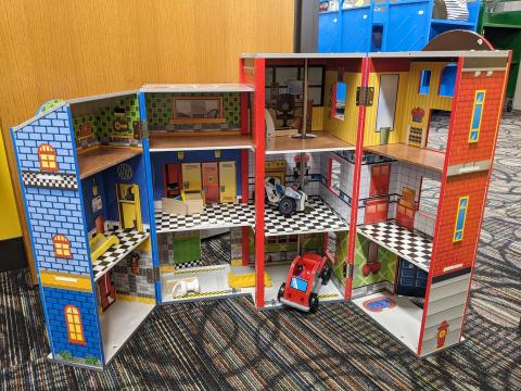 A toy firehouse, open, showing the interior of the playspace.