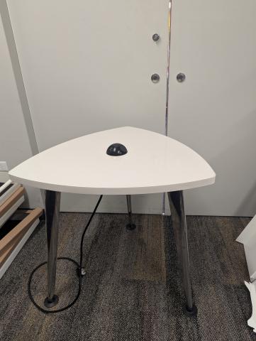 A triangular table with electric sockets and usb plugs 