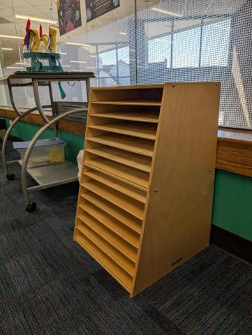 A wooden puzzle storage unit, with 13 slots for puzzles.