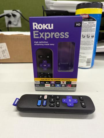 A black Roku remote and box 