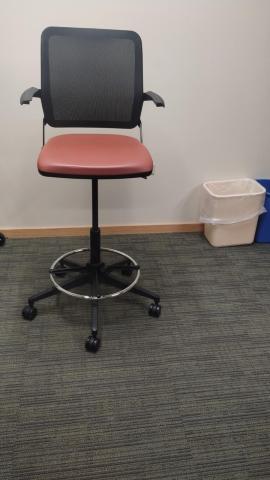 Black adjustable chair with red vinyl cushion