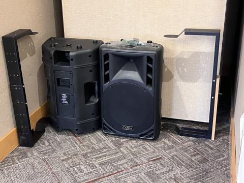 photo of two large black molded plastic PA loudspeaker from Carvin and mounting pieces sitting on a carpeted floor