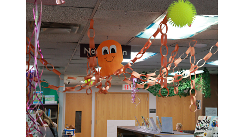 An orange paper octopus with chain links for tentacles hangs from the ceiling.