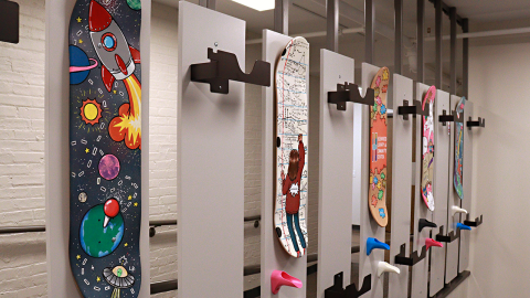 Painted skateboard decks hung on display.