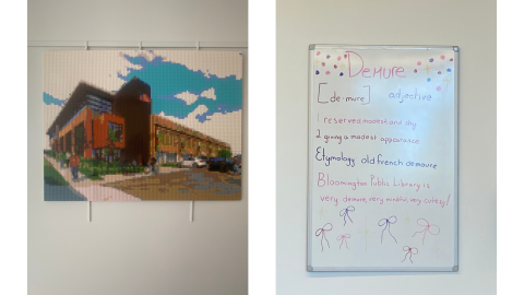 Two pictures side by side: on the left, a cross-stitch of the Bloomington Public Library building hangs on a white wall; on the right, a whiteboard hangs on a white wall, displaying this message: "Demure [de-mure]. adjective. 1. reserved, modest, and shy. 2. giving a modest appearance. Etymology: old French, demoure. Bloomington Public Library is very demure, very mindful, very cutesy!"