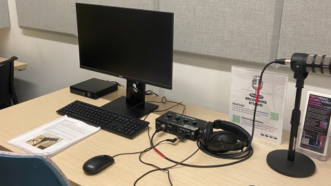 A tabletop recording studio for library patron use. Included in the station are a computer with keyboard and mouse, headphones, microphone, and instruction guide. 