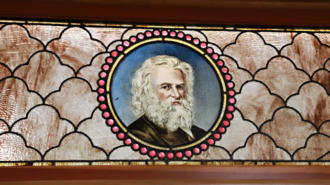 A vintage leaded glass window depicting a man with long hair and a beard. 