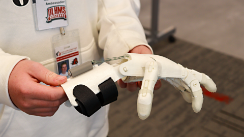 A student holds a 3D-printed hand. 