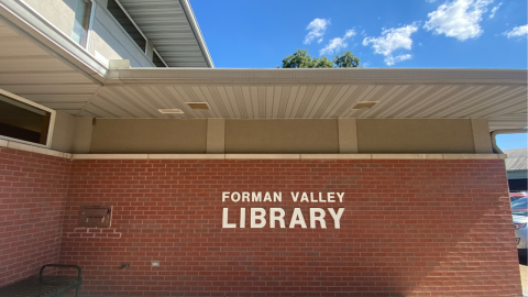 The red brick exterior wall of the Forman Valley Public Library reading, "Forman Valley Library" in white letters. 