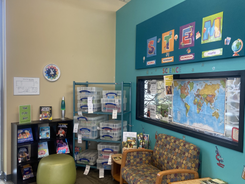 The library's STEM corner featuring kits, books, a world map, and more.