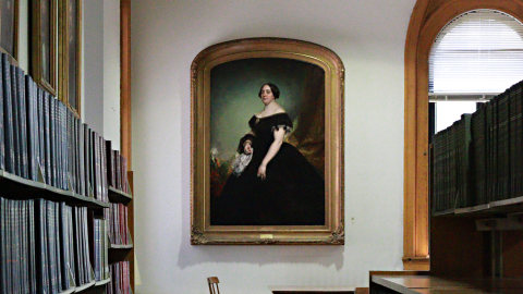Bookshelves. A large painting of a woman in a black dress hanging on the wall.