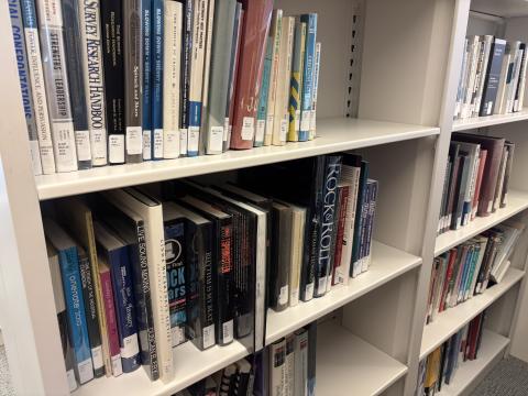 Beige metal bookshelves hold library books from the library's nonfiction collection. 